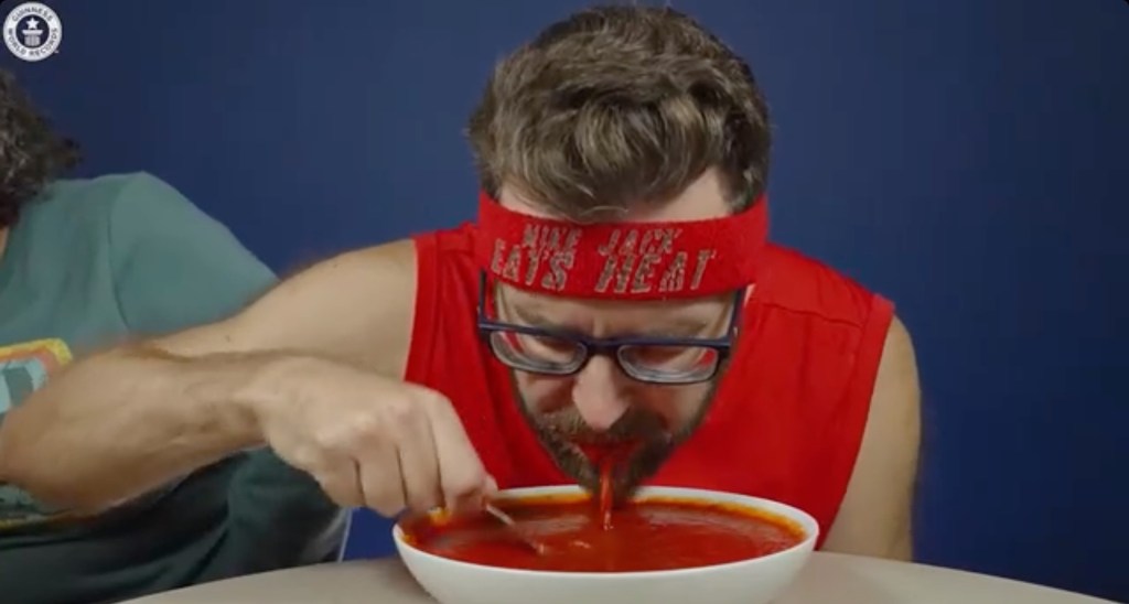 Spicy speed eater Mike Jack consumes two pounds and seven ounces of hot sauce in three minutes, equivalent to the weight of a standard hammer.